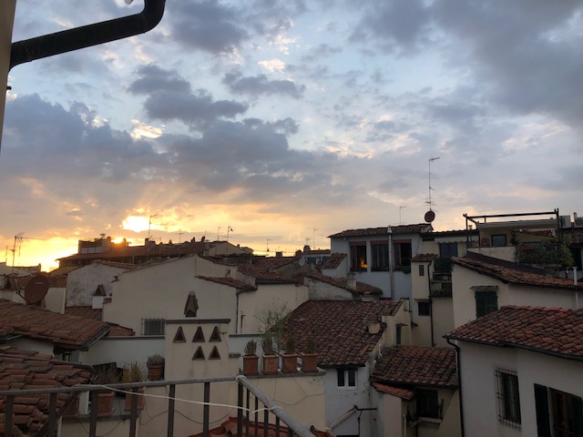 A sunset view out our apartment window of terracotta rooftops.